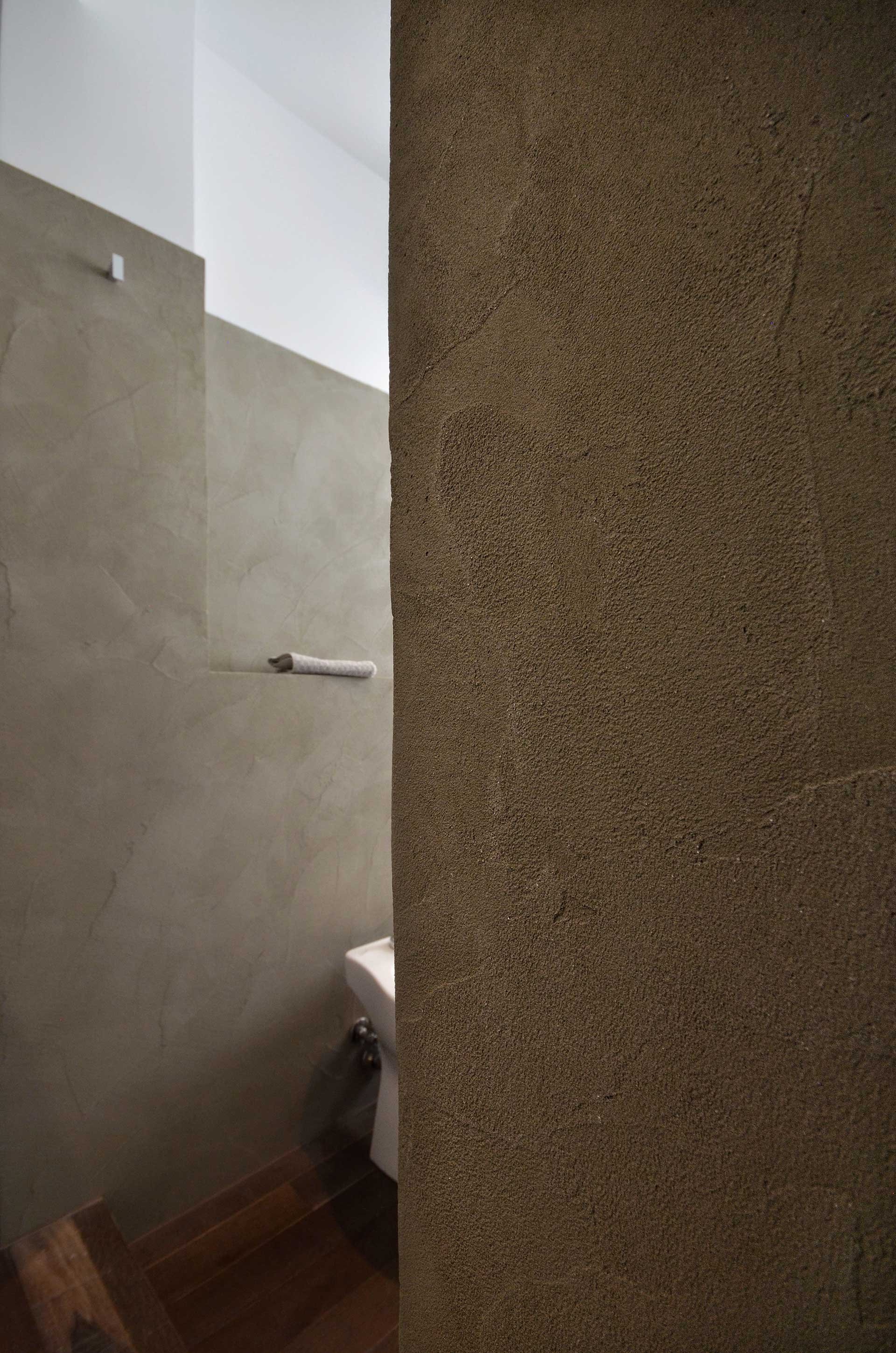 casa CM127. La matericità delle pareti del bagno. Toni caldi, neutri e naturali. Un ambiente molto rilassante.